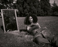 a black and white photo of a woman laying on the grass